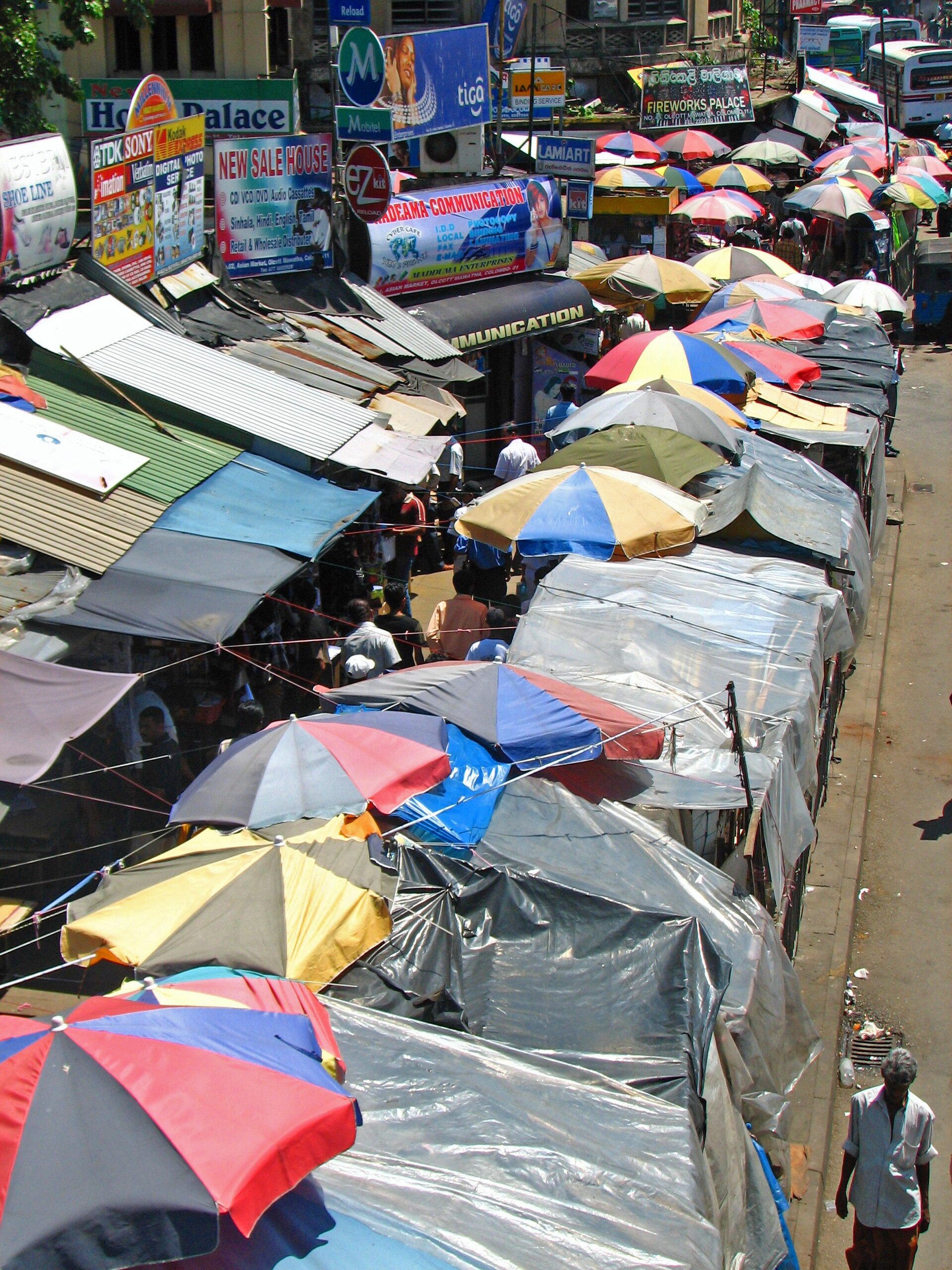 A dense canopy of umbrellas over a street market opposite Colombo Fort station.
